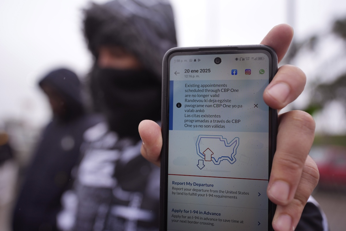 man holding CBP One app screen appts not valid jan 2025