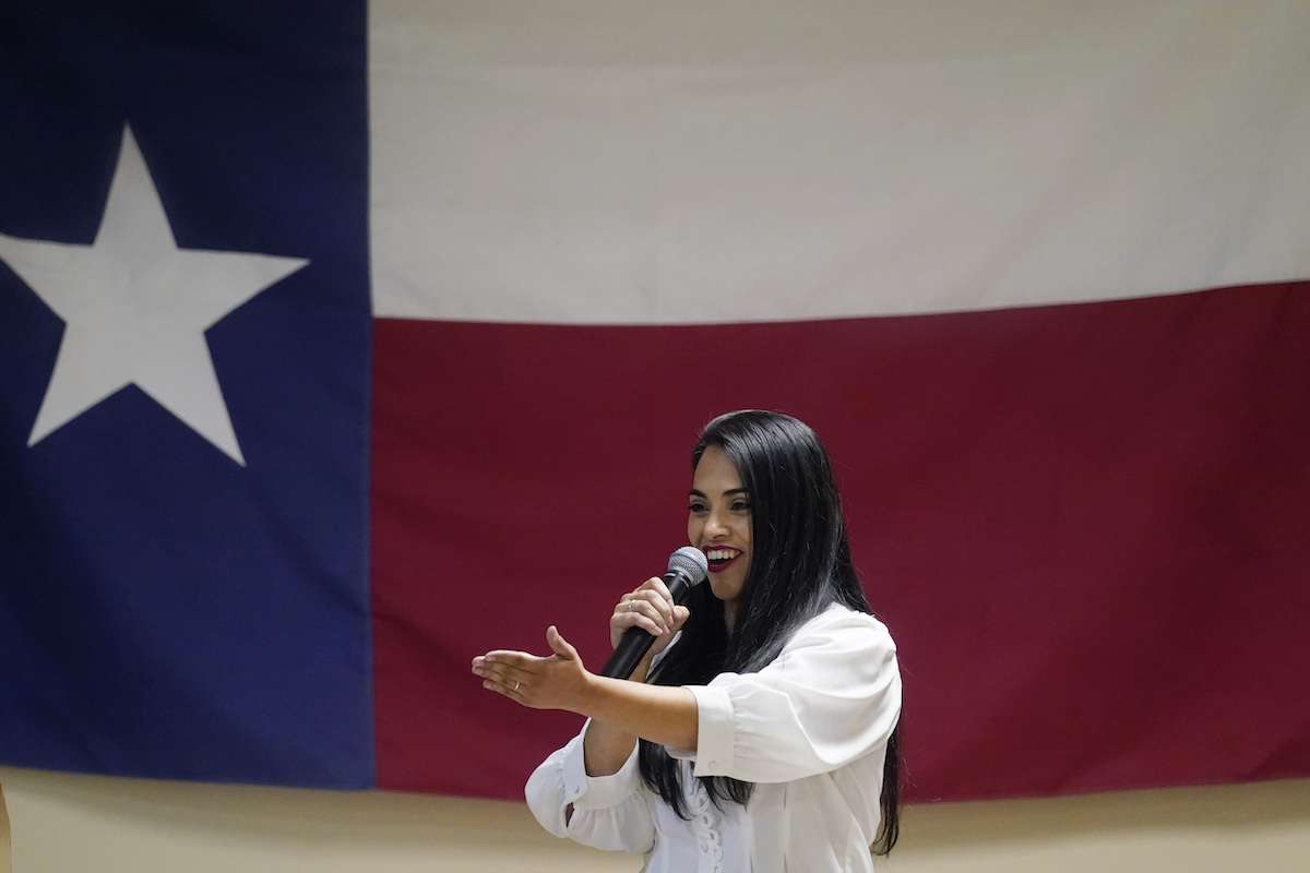 Rep. Mayra Flores speaks in front of Texas flag