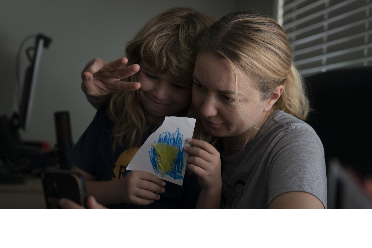 Ukrainian immigrant in CA holding a picture her son made of the flag