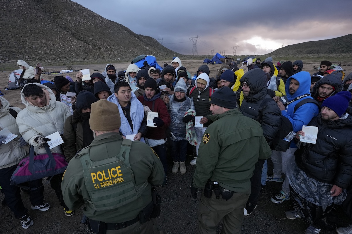 Foto de migrantes de Colombia, China y Ecuador hablando con la Patrulla Fronteriza Feb 2024