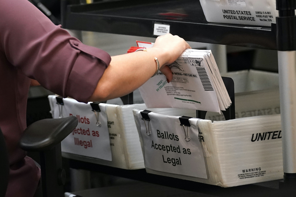 Miami Dade election worker's arm with ballots 10-26-20