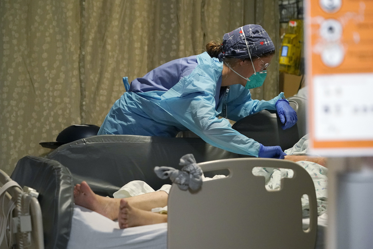 Nurse tends to a hospital patient in acute care