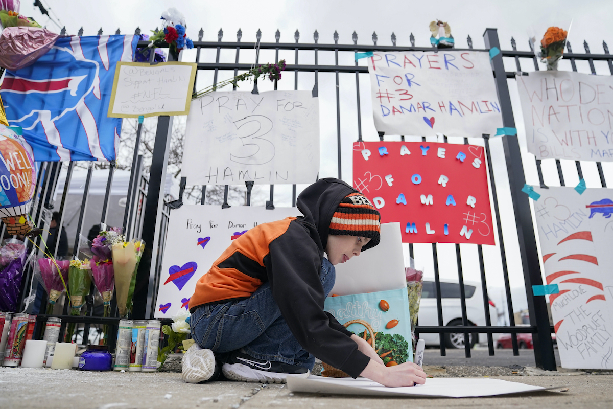 Boy makes signs supporting Damar Hamlin 1/5/2023