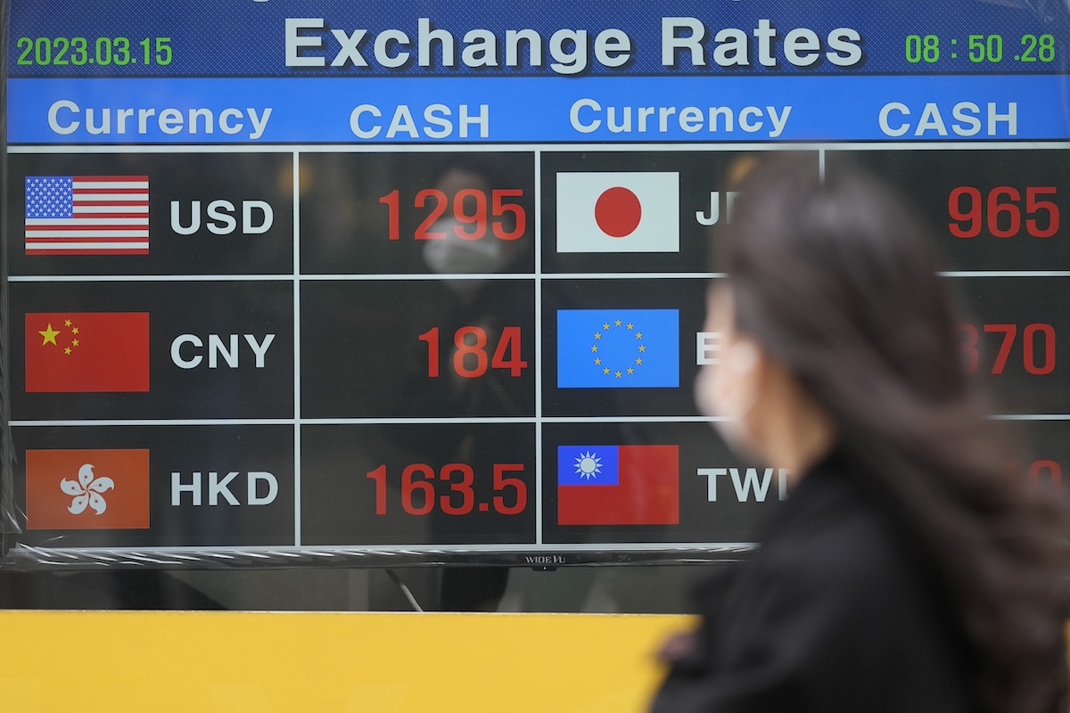 Woman by currency exchange sign in Korea