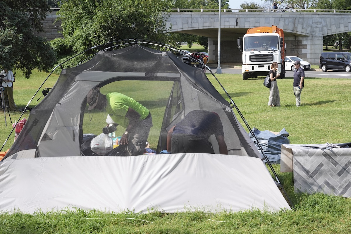 Garbage trucks wait as the homeless empty their belongs from their tents, Aug. 14, 2025, in Washington. (AP)