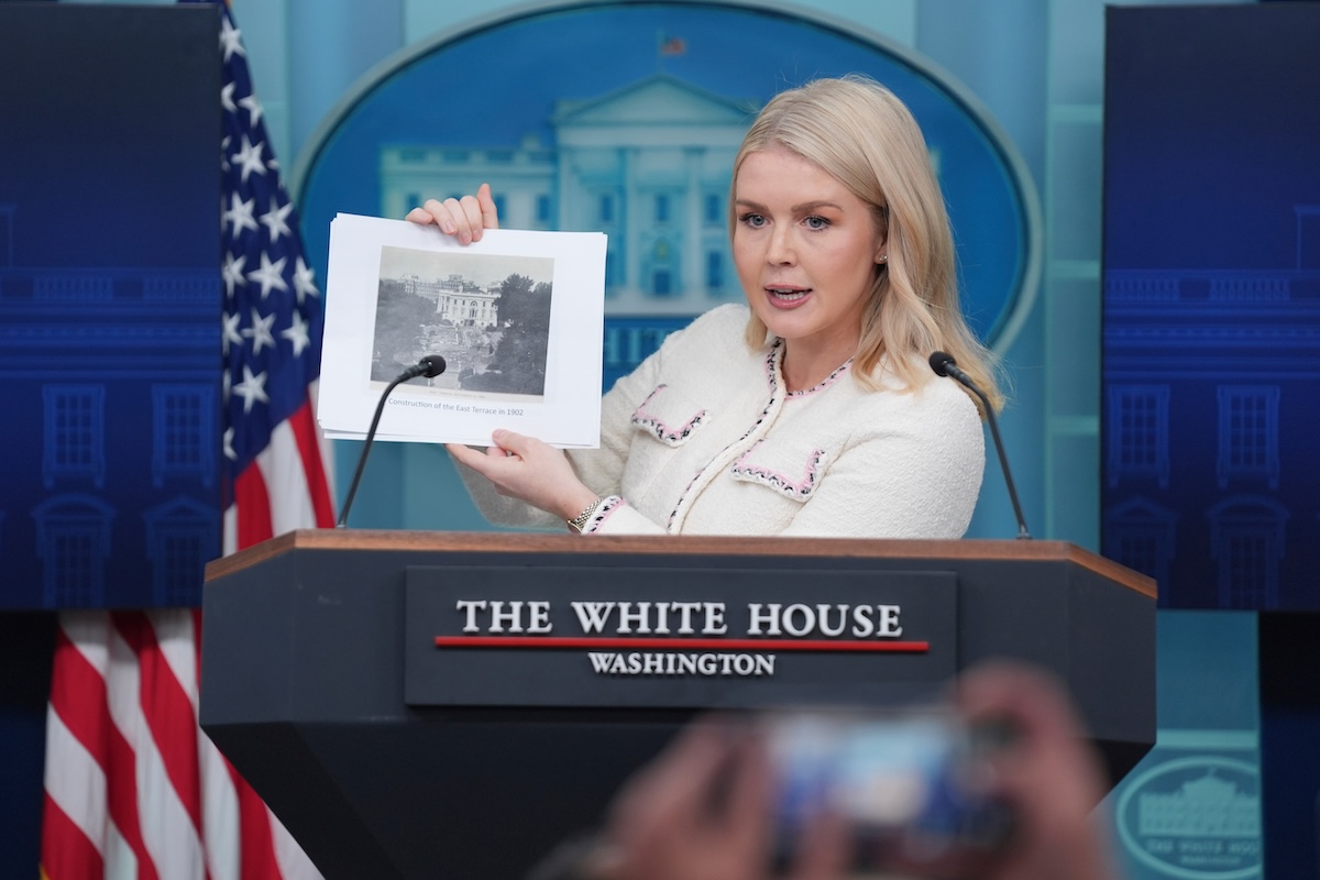 Leavitt holding up historical photo of WH construction