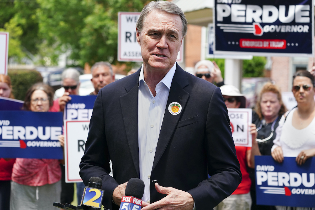 Former Sen. David Perdue in Rutledge Georgia in front of campaign signs5-3-22