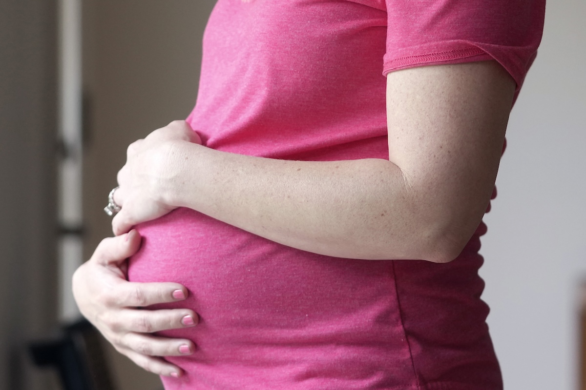 Pregnant woman stands for portrait 05-18-2023