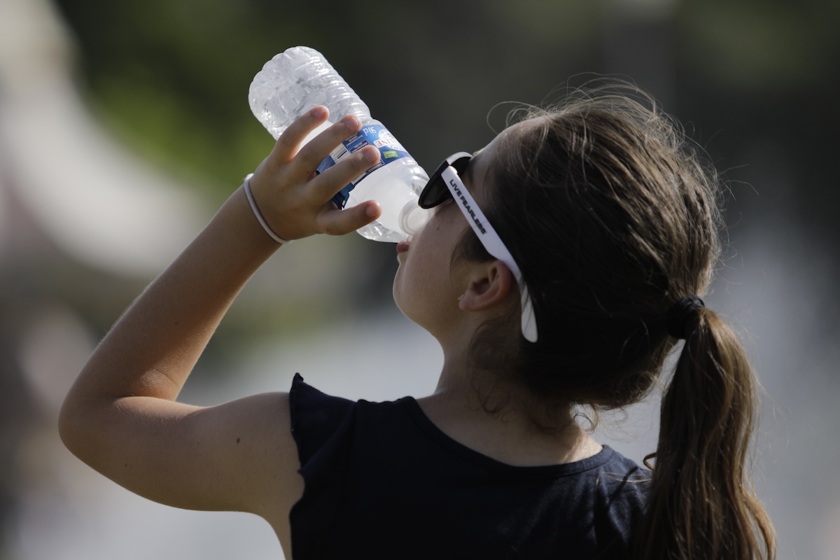 young girl drinking water in paris heat wave