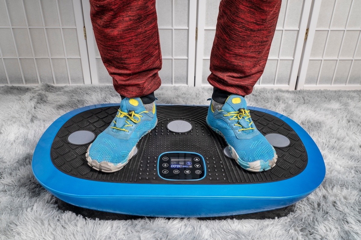 person stands on a vibration plate