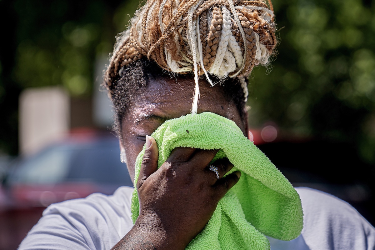 Woman wipes sweat from face in Washington