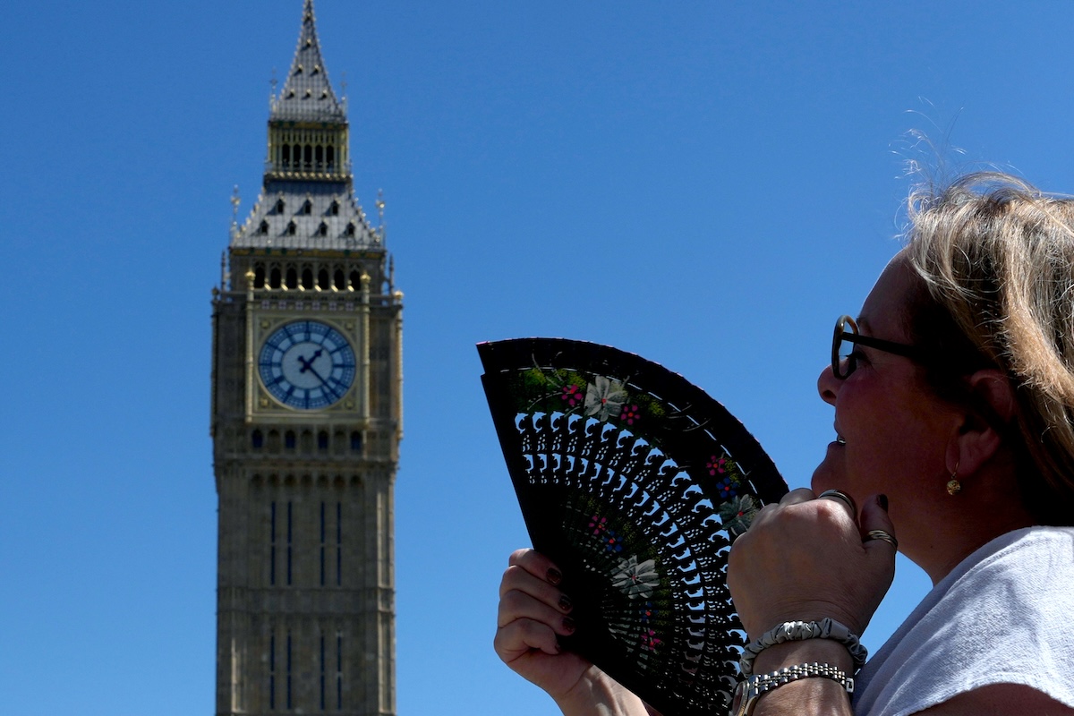 Woman cools herself in front of Westminster in London