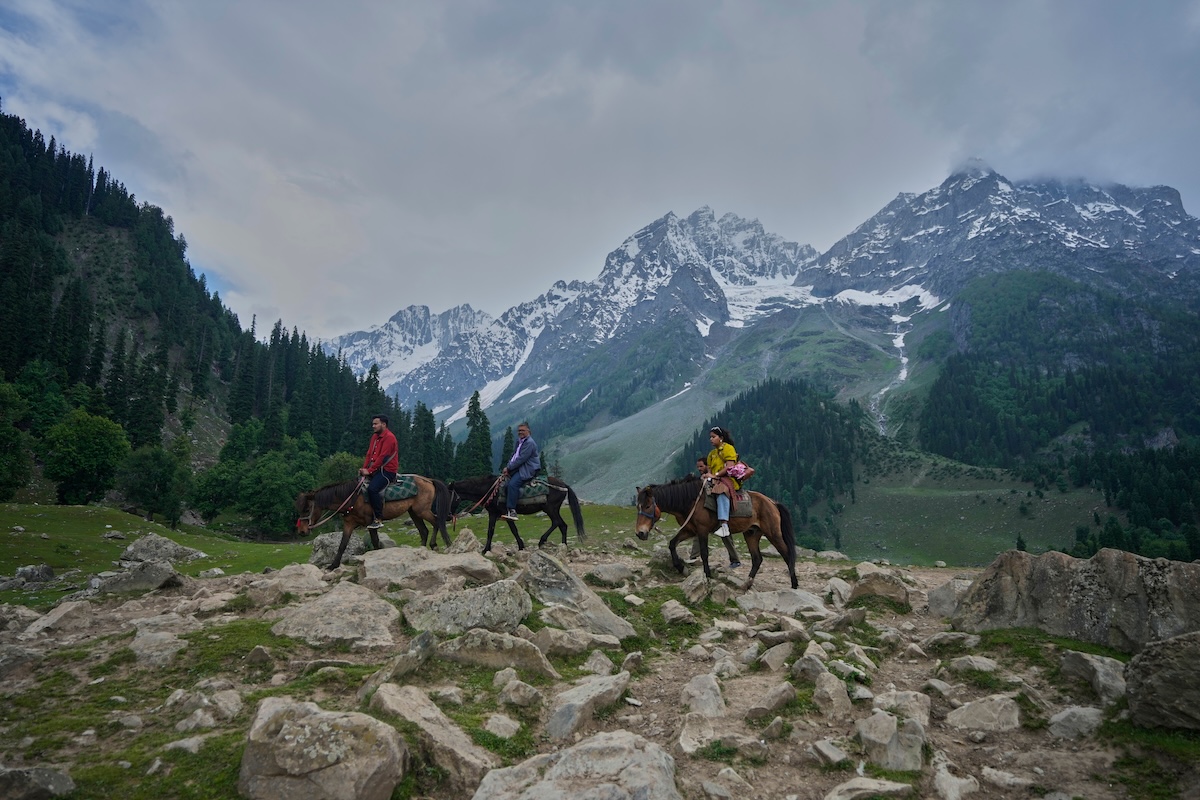 Indian tourists riding horse in Kashmir