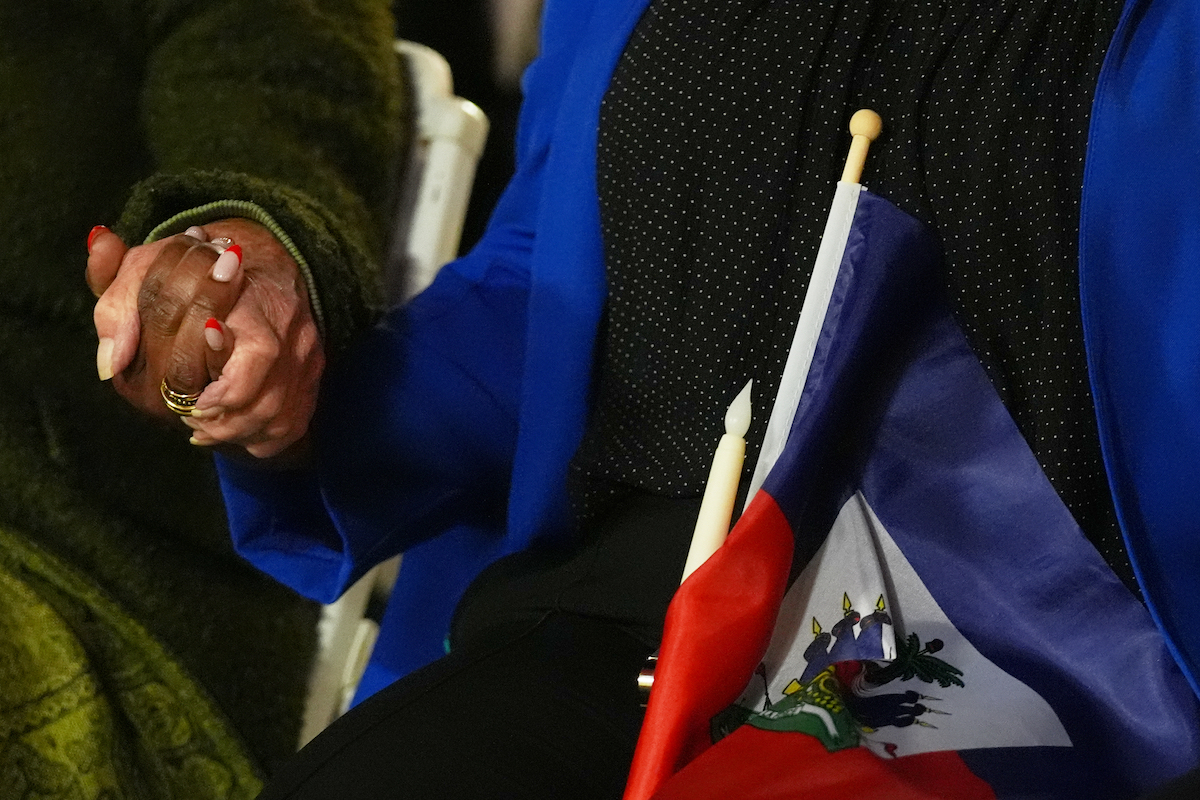 People hold hands at Haiti TPS vigil in Miami in Feb 2026